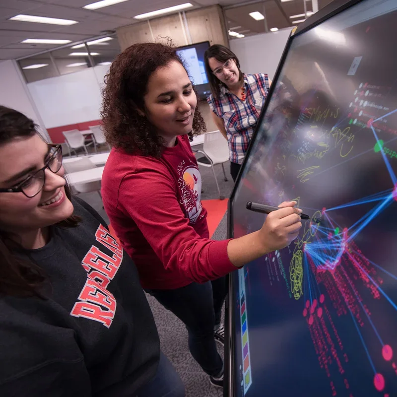 Students writing on digital board