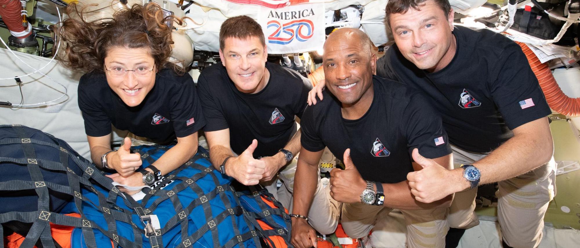 The Artemis II crew pose for a group photo inside the Orion spacecraft on their way home.